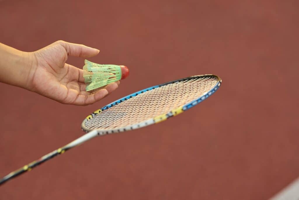 Female child hand holding badminton racquet and shuttlecock